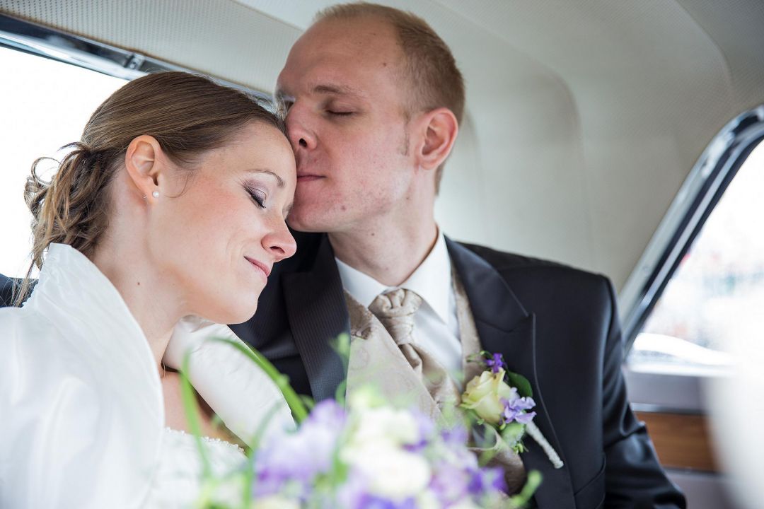 Romantisches Portrait vom Brautpaar in zärtlichem Moment im Auto, Hochzeitsfotos von Peter Vogel, Hamburg