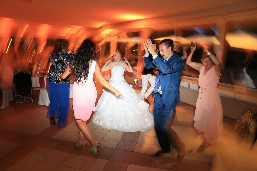 Ausgelassener Tanz der Braut im Brautkleid mit den Gästen, Hochzeitsfotos von Peter Vogel, Hamburg