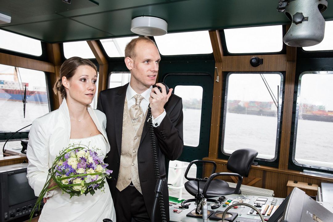 Foto von Brautpaar am Steuerrad eines Kutters im Hamburger Hafen