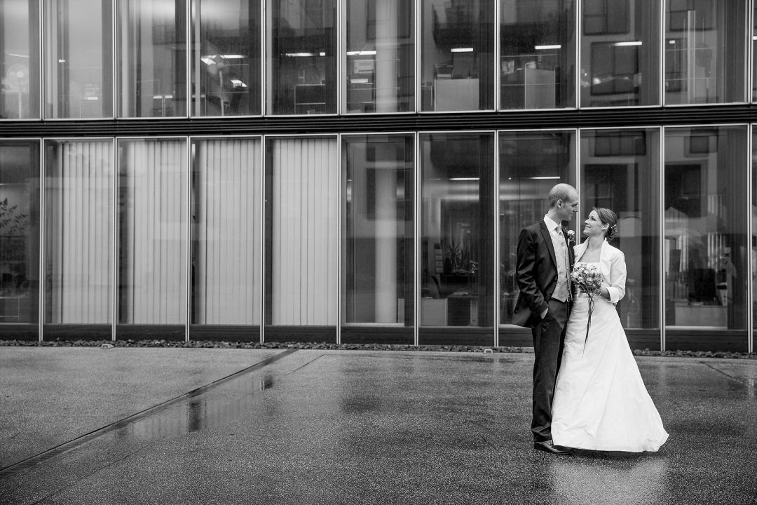 Schwarzweißes Bild vom Brautpaar vor moderner Fassade, Hochzeitsfotos von Peter Vogel, Hamburg