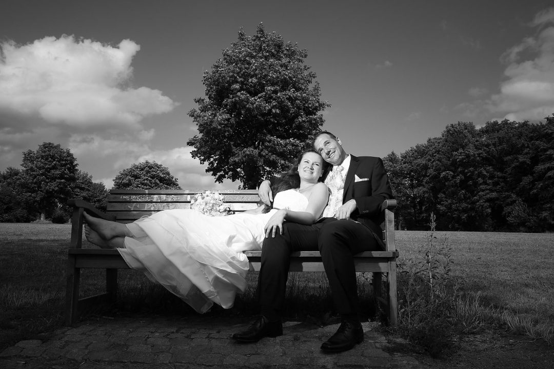 Romantische Szene auf Parkbank mit Brautaar. Schwarzweiß Hochzeitsfotos von Peter Vogel, Hamburg