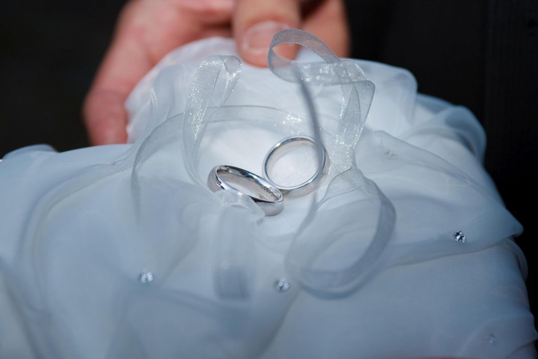 Braut zeigt Eheringe auf weißem Tuch, Hochzeitsfotos von Peter Vogel, Hamburg