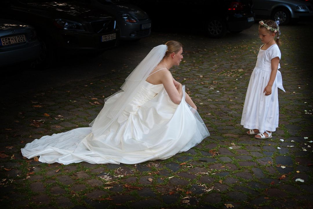 Braut im weißen Brautkleid tröstet kleinen Gast, Hochzeitsfotos von Peter Vogel, Hamburg
