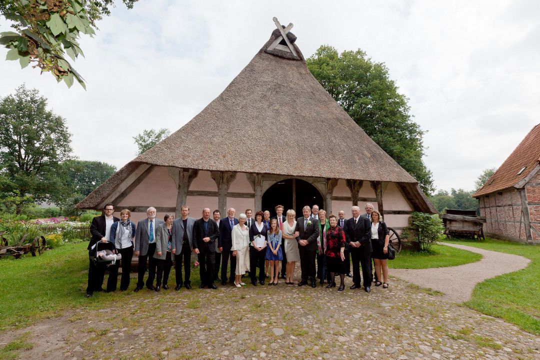 Gruppenfoto mit Hochzeitspaar vor historischem Bauernhof, Hochzeitsfotos von Peter Vogel, Hamburg